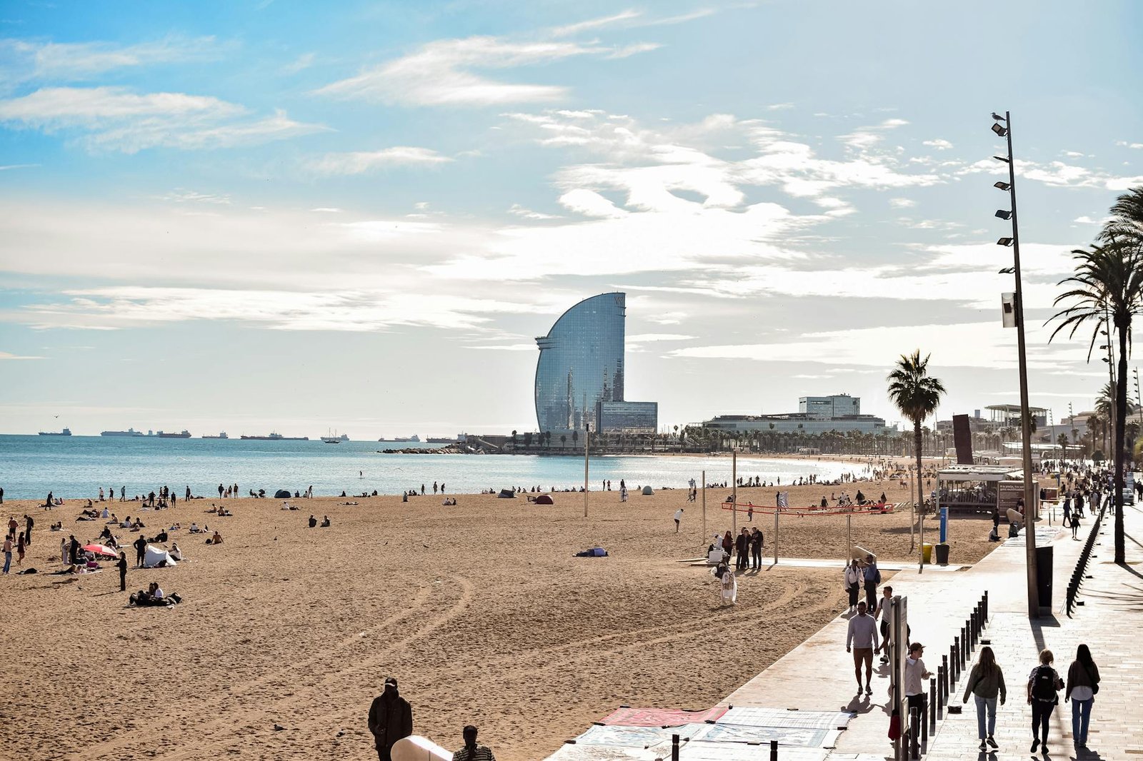 A vibrant day at Barceloneta Beach, showcasing the iconic W Hotel and lively atmosphere.
