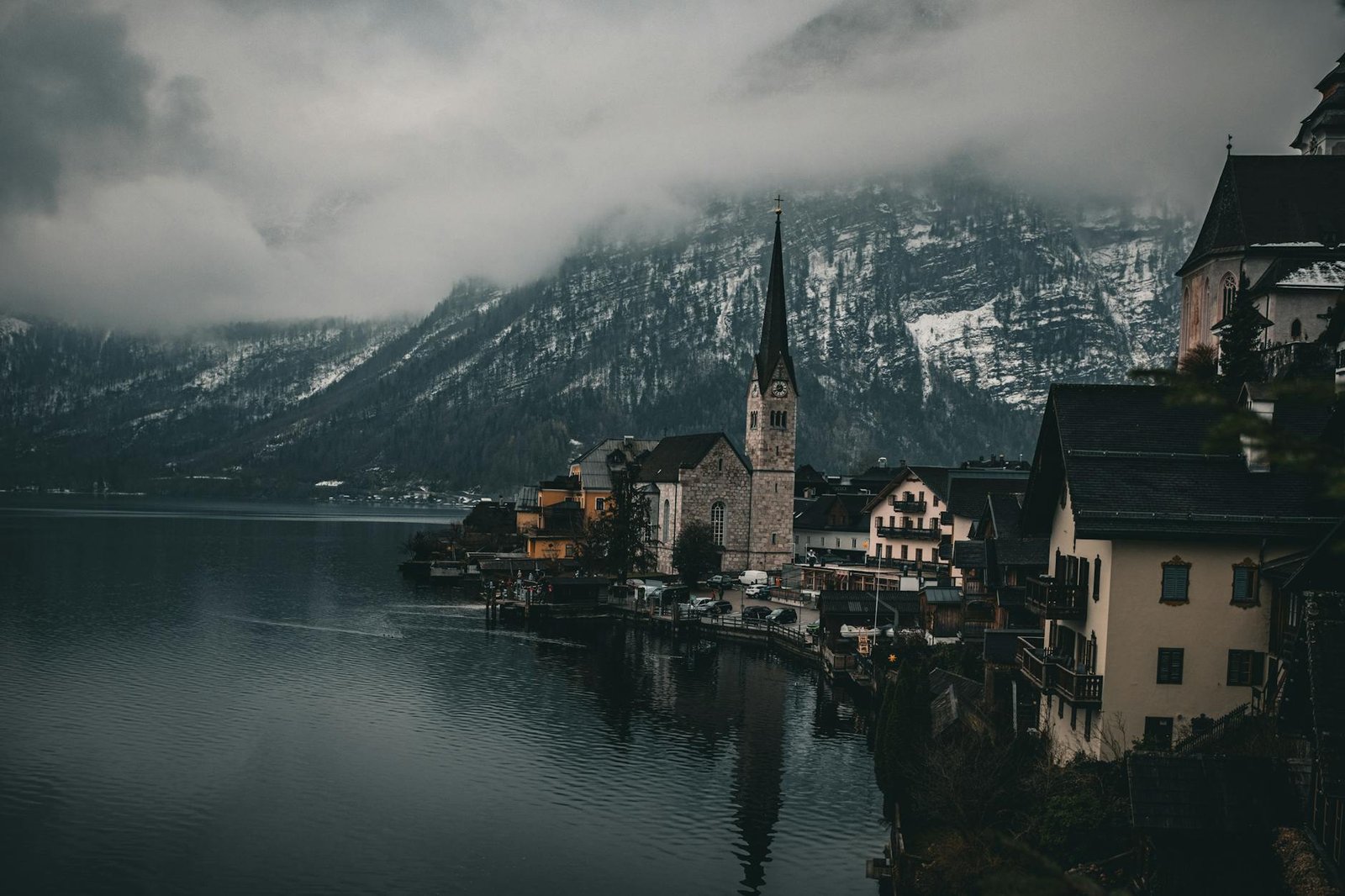 Serene winter landscape of Hallstatt with snow-capped mountains and tranquil lake.